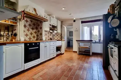 a large kitchen with white cabinets and a tile floor at Hisa Brdo Guesthouse in Tolmin