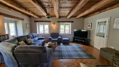 a living room with a couch and a tv at Hisa Brdo Guesthouse in Tolmin