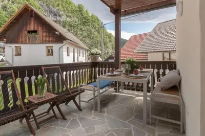 a patio with a table and chairs on a balcony at House Bella in Bohinjska Bela