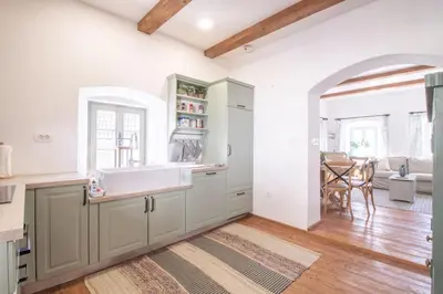 a kitchen with white cabinets and a sink at House Bella in Bohinjska Bela