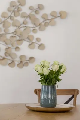 a vase filled with white flowers on a table at House Bella in Bohinjska Bela