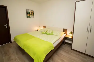 a bedroom with a bed with a green blanket on it at Accommodation Resman in Bohinj