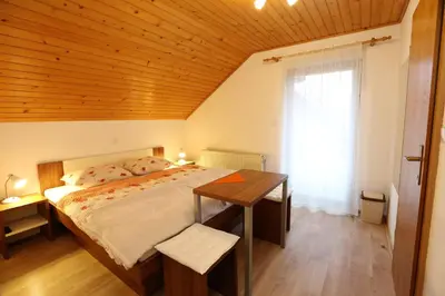 a bedroom with a bed and a wooden ceiling at Accommodation Resman in Bohinj