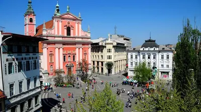 a group of people walking around a street in a city at Twix apartment in Ljubljana