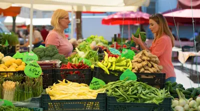 two women standing in a market with fruits and vegetables at Twix apartment in Ljubljana