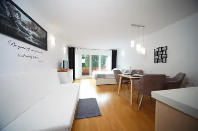 a living room with a white couch and a table at Apartma Prisank Kranjska Gora in Kranjska Gora