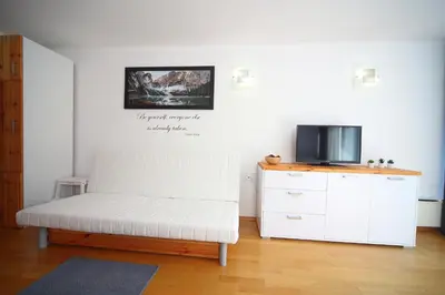 a living room with a white couch and a tv at Apartma Prisank Kranjska Gora in Kranjska Gora