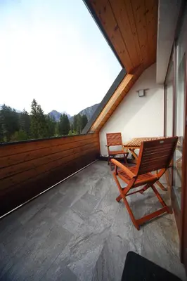 a balcony with two chairs and a table on it at Apartma Prisank Kranjska Gora in Kranjska Gora