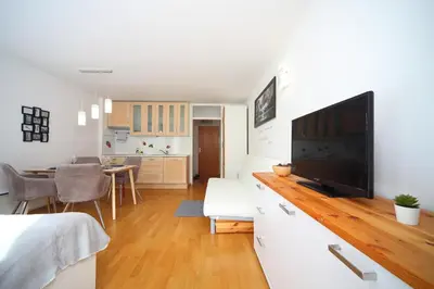 a living room with a television and a dining room at Apartma Prisank Kranjska Gora in Kranjska Gora