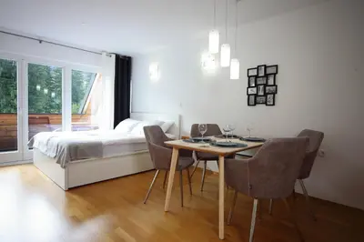 a bedroom with a bed and a table and chairs at Apartma Prisank Kranjska Gora in Kranjska Gora