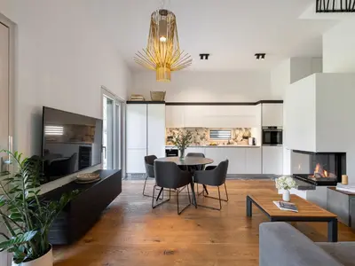 a kitchen and living room with a table and chairs at Maison du Soleil in Kranjska Gora