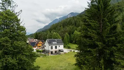 a house on a hill with mountains in the background at Maison du Soleil in Kranjska Gora