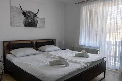 a bedroom with a bed with a bull head on the wall at Penzion ob Ribniku in Podlehnik