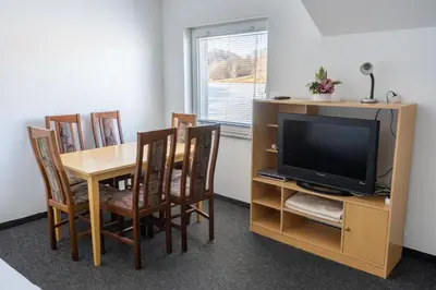 a dining room with a table and a television at Penzion ob Ribniku in Podlehnik