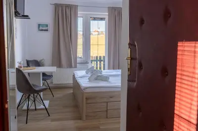 a bedroom with a bed and a desk and a window at Penzion ob Ribniku in Podlehnik