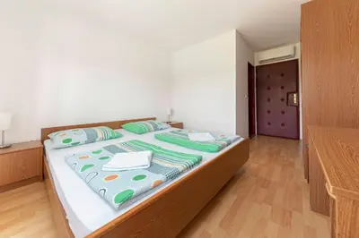 a bedroom with a large bed with green pillows at Penzion ob Ribniku in Podlehnik