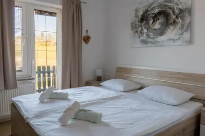 a bedroom with a white bed with two pillows at Penzion ob Ribniku in Podlehnik