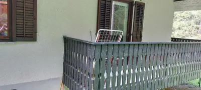 a green fence on a porch with a window at Apartma Anja in Zgornje Gorje