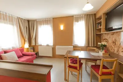 a living room with a red couch and a table at City Centre Apartments in Ljubljana