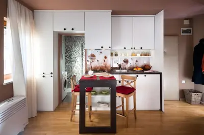 a kitchen with white cabinets and a table with chairs at City Centre Apartments in Ljubljana