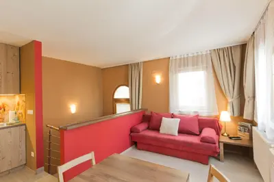 a living room with a red couch and a table at City Centre Apartments in Ljubljana