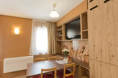 a dining room with a table and a tv at City Centre Apartments in Ljubljana