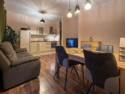 a living room with a table and chairs and a couch at Vila Bovec Sunrise apartment with balcony in Bovec