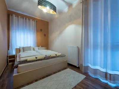 a bedroom with a bed and a large window at Vila Bovec Sunrise apartment with balcony in Bovec