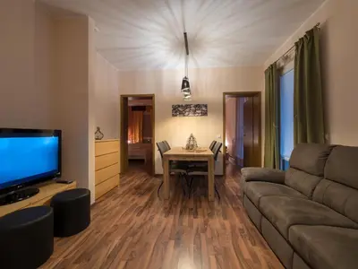 a living room with a couch and a table at Vila Bovec Sunrise apartment with balcony in Bovec