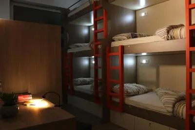 a room with three bunk beds and a desk at Hostel Tivoli in Ljubljana