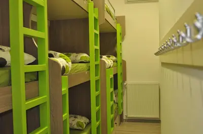 a room with bunk beds with green shelves at Hostel Tivoli in Ljubljana