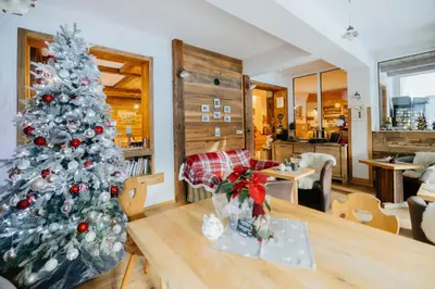 a christmas tree in a living room with a table at Eko hiša-Eco House Na razpotju in Solčava