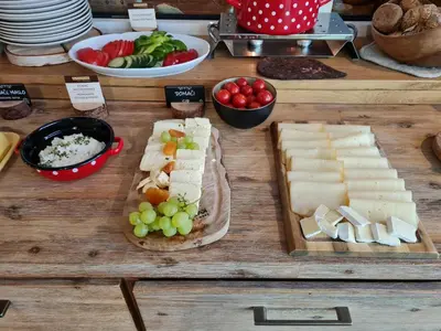 a table topped with cheese and grapes and other foods at Eko hiša-Eco House Na razpotju in Solčava
