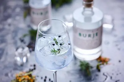 a glass of water with a flower in it at Eko hiša-Eco House Na razpotju in Solčava