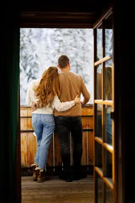 a man and a woman looking out of a door at Eko hiša-Eco House Na razpotju in Solčava