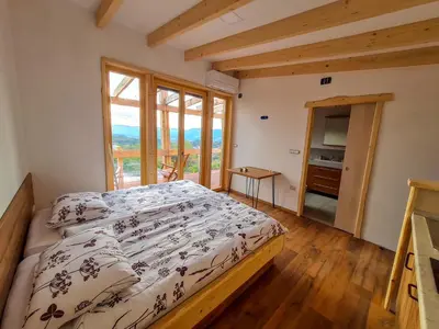 a bedroom with a bed and a large window at Panorama glamping Vipavska dolina in Dobravlje