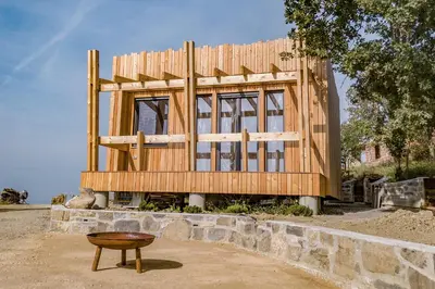 a wooden house is being built on a stone wall at Panorama glamping Vipavska dolina in Dobravlje