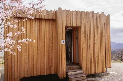 a wooden building with a door and a fence at Panorama glamping Vipavska dolina in Dobravlje