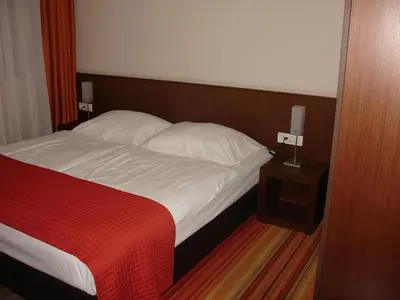 a bedroom with a bed with a red blanket and white pillows at B&B Janežič in Ljubljana