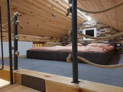 a bedroom in a log cabin with two beds at Apartment Mastnak - Private Wellness & Jacuzzi in Laško