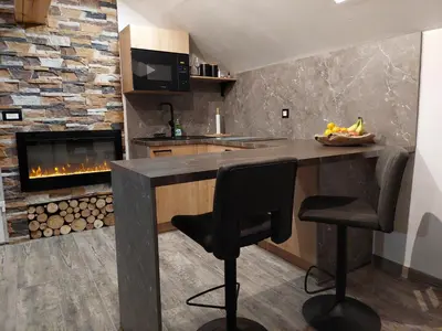 a kitchen with a counter and a fireplace at Apartment Mastnak - Private Wellness & Jacuzzi in Laško
