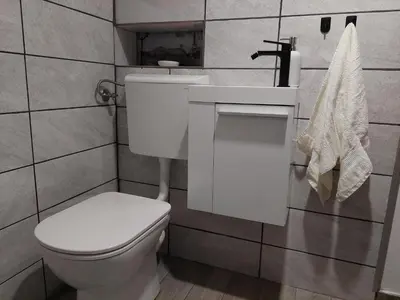 a bathroom with a white toilet and a sink at Apartment Mastnak - Private Wellness & Jacuzzi in Laško