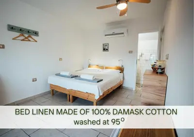 a bed in a white room with a bedlinear made of davis at Villa Lapis in Črni Kal