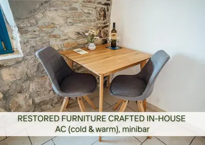 a wooden table with two chairs and a bottle of wine at Villa Lapis in Črni Kal