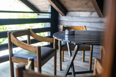 a table and chairs on a porch with a cup on it at Apartma med vinogradi in Ljutomer