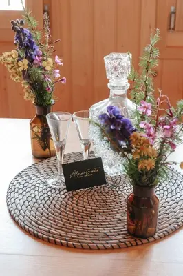 a table with two wine glasses and flowers in vases at Chalet Orlica Velika Planina in Stahovica