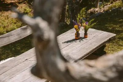 two vases with flowers sitting on a wooden table at Chalet Orlica Velika Planina in Stahovica