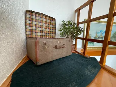 an old suitcase sitting on a floor next to a window at Cilka`s house, authentic homestay near Lipica in Sežana