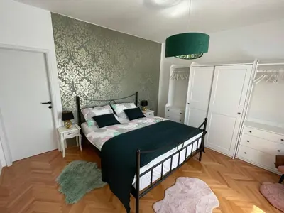 a bedroom with a bed and a green wall at Cilka`s house, authentic homestay near Lipica in Sežana