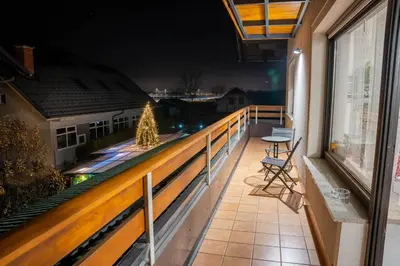 a balcony with a chair and a christmas tree at Apartma AJJA in Šenčur